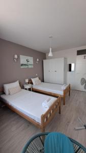 two beds in a room with two chairs at Double Room, Shared bathroom- Rooms GEA in Prizren