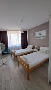 a room with three beds and a table and a chair at Double Room, Shared bathroom- Rooms GEA in Prizren +8 photos