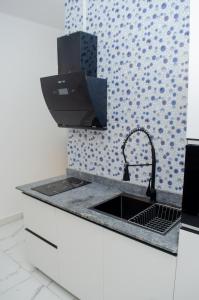 a kitchen with a sink and aaucet at CHROME Résidences Fidjrossè PLAGE in Cotonou