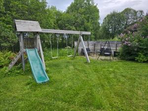 a playground with a slide in the grass at Barnevennlig leilighet nær båthavn og sentrum in Tromsø