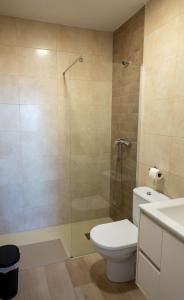 a bathroom with a toilet and a glass shower at Casa Vella de Casa Torrent in Canet de Mar