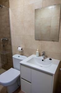 a bathroom with a toilet and a sink and a mirror at Casa Vella de Casa Torrent in Canet de Mar