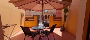 a table and chairs with an umbrella on a balcony at Siel Oneiro House in Ermoupoli