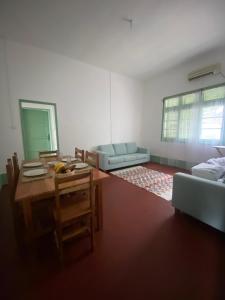 a living room with a table and a couch at CASA da Baía by NaturAlegre in São Tomé