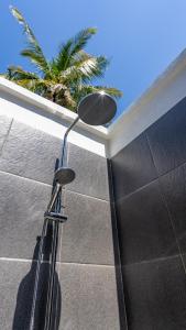 a shower head in a bathroom with a palm tree at Resort Gili Trawangan - Private Pool Bungalow in Gili Trawangan