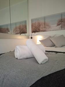 a bedroom with a bed with white towels on it at Appartement neuf proche Nantes avec parking in Carquefou
