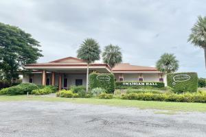 un resort con palme di fronte a un edificio di New Place Resort a Udon Thani