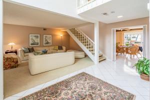 ein Wohnzimmer mit einer weißen Couch und einer Treppe in der Unterkunft Keys Retreat by Paradise Retreats in Ventura + 32 Fotos