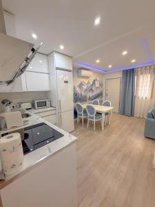 マドリードにあるCharming Madrid Apartment 6 paradas metro El Retiroのテーブルと椅子のあるキッチンとリビングルーム