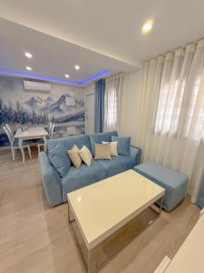 マドリードにあるCharming Madrid Apartment 6 paradas metro El Retiroの青いソファとテーブルのあるリビングルーム