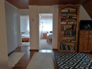 a living room with a book shelf and a bedroom at LiLu Apartman in Felsőtárkány +34 photos