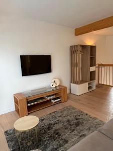 a living room with a flat screen tv on a wall at Maison cosy 64 m2 à 10 min de Strasbourg, idéale familles in Lampertheim