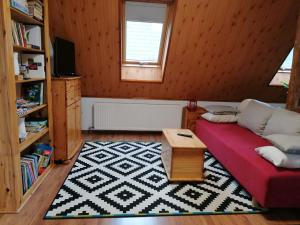 a living room with a red couch and a table at LiLu Apartman in Felsőtárkány