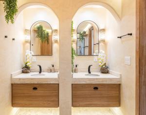 a bathroom with two sinks and two mirrors at Copa Beach Studios Design in Rio de Janeiro +99 photos