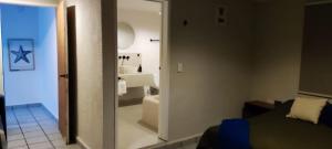 un baño con una puerta de cristal que conduce a un dormitorio en Casa Eclipse, en Cancún