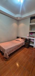 a bedroom with a bed and a wooden floor at Casa Sarita y Manuel in Curridabat