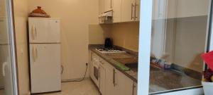 a kitchen with a white refrigerator and a sink at Dyar alboughaz in Hajreien