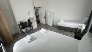 a bedroom with a large white bed and a desk at Saint Annes Guest House - 22 Berkeley in Dublin
