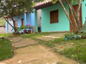 a blue house with a door and a yard at Chalés Rancho Fênix in Palmeiras +6 photos