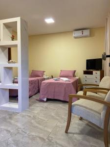 a room with two beds and a tv in it at Chalés Rancho Fênix in Palmeiras +6 photos