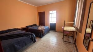 ein Hotelzimmer mit zwei Betten und einem Fenster in der Unterkunft Puebla centro casa Peerza in Puebla