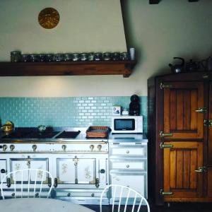 a kitchen with a stove and a microwave at Bed&Breakfast la Cabanya de Beget in Beget
