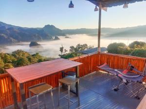 a deck with a table and chairs and a view of the mountains at ภูลังกาซีวิว in Ban Sakoen