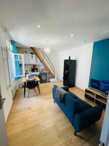 een woonkamer met een blauwe bank en een tafel bij Le duplex biterrois in Béziers