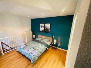 een slaapkamer met een bed en een blauwe muur bij Le duplex biterrois in Béziers