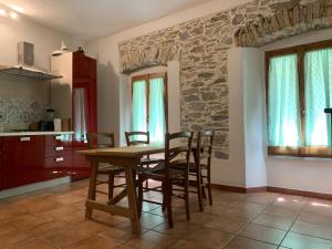 a kitchen with a wooden table and chairs at B&B Casa Vitale in Villasalto