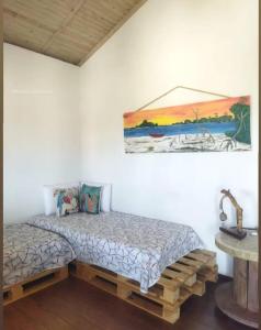 a bedroom with a bed and a painting on the wall at Barefoot KiteHouse in Luis Correia