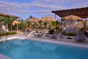 ein Pool im Resort mit Liegen und Sonnenschirmen in der Unterkunft Cocolobos Beach Resort in Bocapán