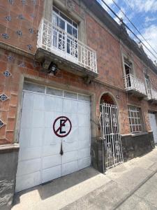 ein weißes Garagentor mit einem Parkverbotsschild in der Unterkunft Puebla centro casa Peerza in Puebla