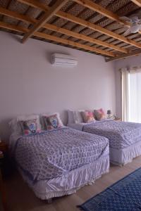 ein Schlafzimmer mit zwei Betten und einer Couch in der Unterkunft Cocolobos Beach Resort in Bocapán + 25 Fotos