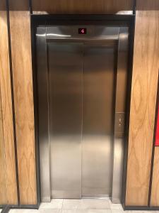 a metal elevator door with a sign on it at Austral Apartamentos in Ushuaia