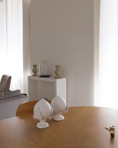 two white speakers sitting on top of a wooden table at Via Chiodo Luxury Apartment in La Spezia