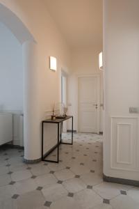 a white room with a table and a door at Via Chiodo Luxury Apartment in La Spezia