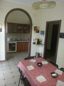 a kitchen with a table with a red table cloth at Bed & Breakfast Hollywood in Villarosa