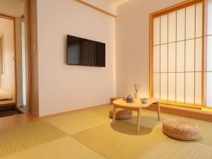 a living room with a table and a tv at Dainichiji no Yado Kyoto Kisshoin - Vacation STAY 84544v in Kyoto
