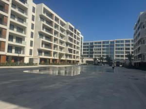a large apartment building with a fountain in front of it at Sea breeze Park residens 2 in Baku