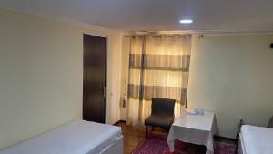 a room with a bed and a table and a chair at Muhammadali hostel in Bukhara