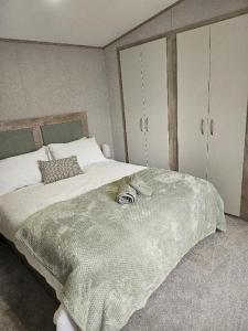 a bedroom with a large bed with a silver blanket at Stunning 6 Berth Caravan Near To The Beach At Pakefield Ref 68115Cr in Lowestoft