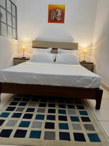 una camera da letto con un letto grande con due lampade di Nexus Lodge a Abidjan