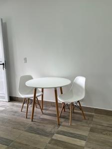 a white table and two white chairs in a room at Los Fresnos 50 dpto 6 in Oro Verde