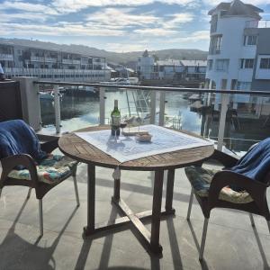 a table with a bottle of wine on a balcony at South Quay no 6 in Knysna