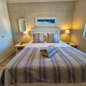 a bedroom with a large bed with two tables and two lamps at South Quay no 6 in Knysna
