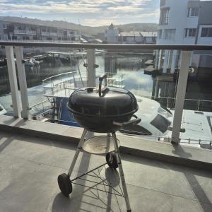 a grill sitting on a stand on a balcony at South Quay no 6 in Knysna +10 photos