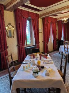 a dining room with a table with food on it at Château St Sulpice Chambre RUBIS in Condal +10 photos