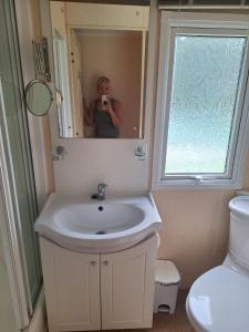 a woman taking a picture of a bathroom sink at Wonderful views in Startforth +5 photos