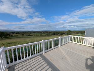 a large wooden deck with a view of a field at Wonderful views in Startforth